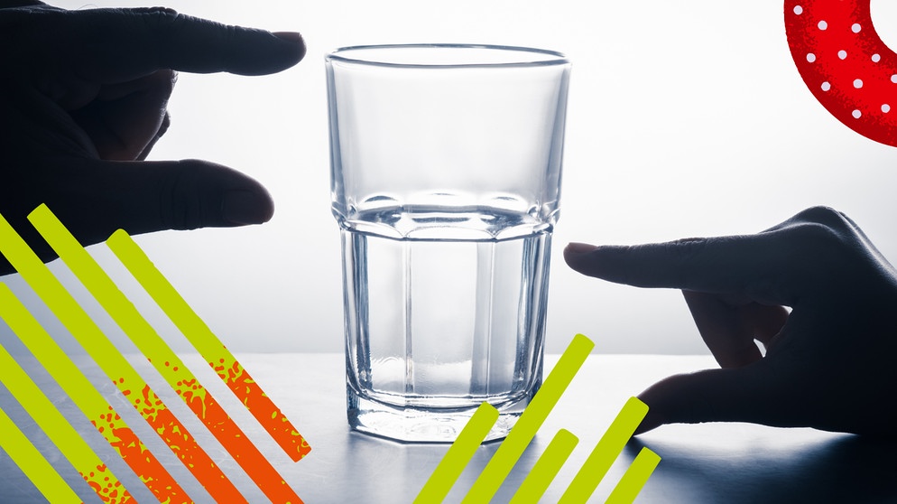 Ein Glas, zur Hälfte mit Wasser gefüllt. Eine Hand zeigt mit den Fingern halb voll, eine andere halb leer. | Bild: colourbox.com